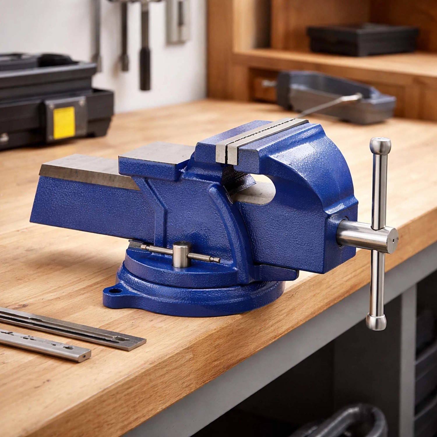 Blauer Wiltec Schraubstock mit 150mm Klemmbacken und Amboss auf einer Holzwerkbank. Robustes Spannwerkzeug.