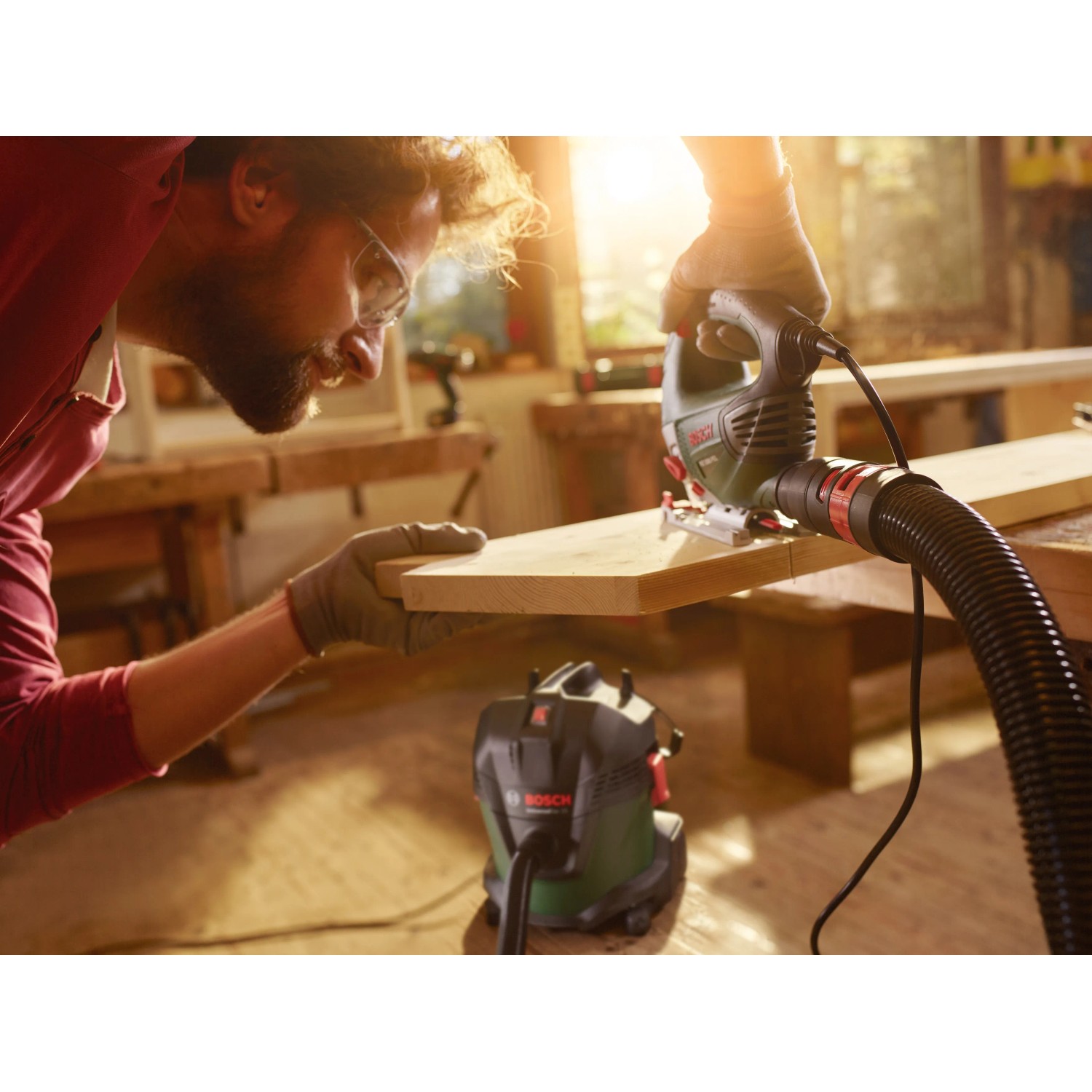 Bosch AdvancedVac 20 Nass- und Trockensauger im Einsatz mit Stichsäge an Holzbrett.