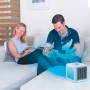 Livington ArcticAir Klimagerät in Weiß, mit kühlendem Luftstrom und zwei Personen im Hintergrund.