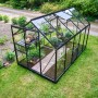 Schwarzes Halls Gewächshaus Popular 6,2 m² mit Pflanzen im Garten.