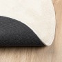 Beiger runder Kurzflor-Teppich OVIEDO auf Holz, Unterseite mit Anti-Rutsch-Beschichtung sichtbar.