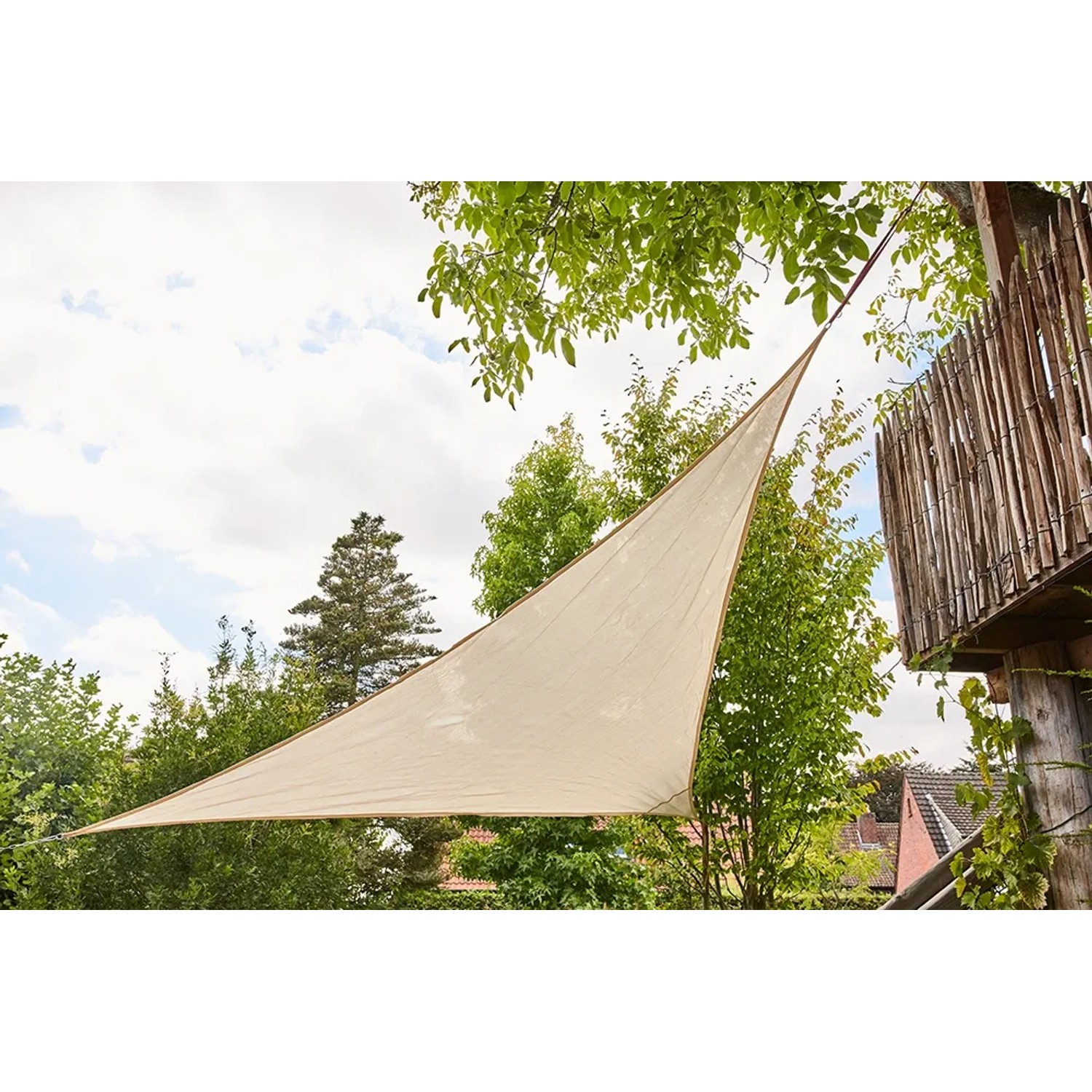 Ecru-farbenes, dreieckiges Siena Garden Sonnensegel Solino (3,6x3,6x3,6 m) im Garten.