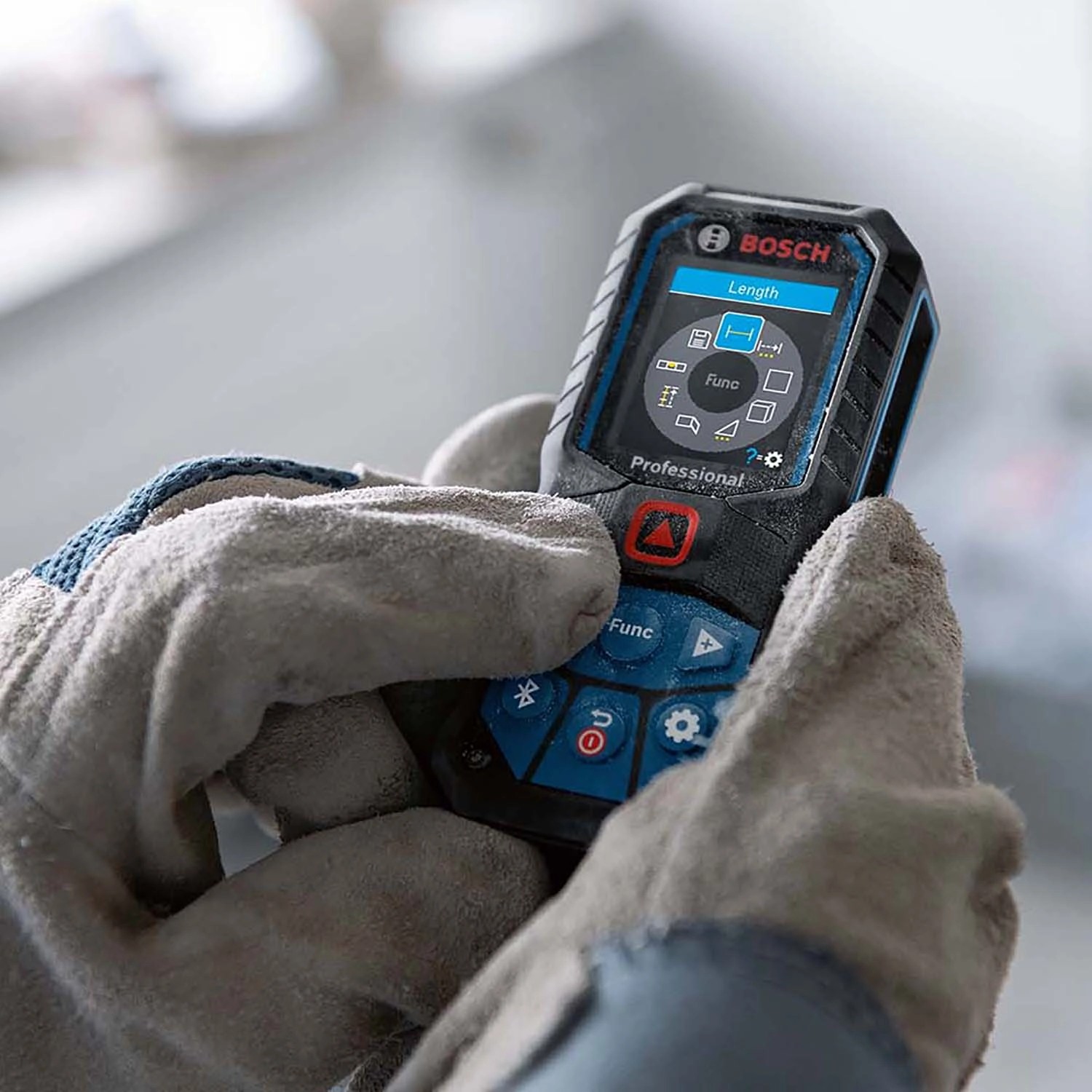 Bosch Professional GLM 50-27 C Laser-Entfernungsmesser in Hand mit Arbeitshandschuh.