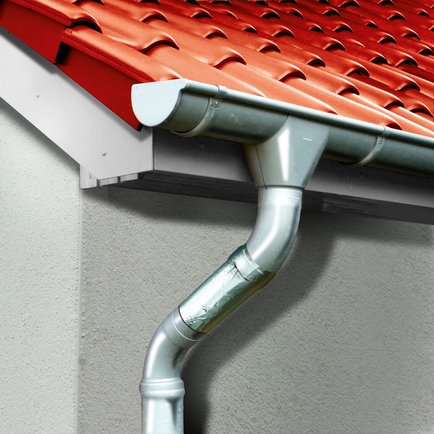 Silbernes Fallrohr am Hausdach mit MEM Bitumen-Band Alu 10 cm x 10 m abgedichtet.