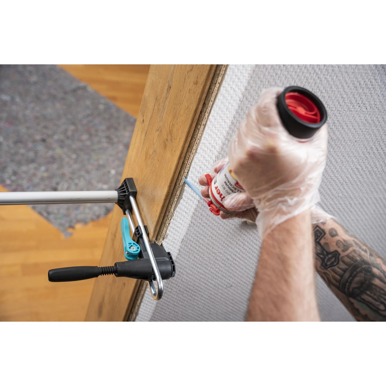 Person montiert Türfutter mit wolfcraft Montageset. Bauschaum wird zwischen Zarge und Wand gespritzt, Spannwerkzeug fixiert.