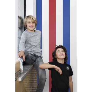 ESTAhome Streifen Tapete in Rot, Weiß und Blau im Kinderzimmer mit zwei Jungen.