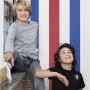 ESTAhome Streifen Tapete in Rot, Weiß und Blau im Kinderzimmer mit zwei Jungen.