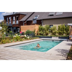 Pool mit Schwimmer vor Haus, Summer Fun Wärmepumpe Green Energy für bis zu 60.000 l Poolinhalt.