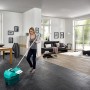 Frau nutzt Leifheit Wischtuchpresse Profi mit Rollen zum Reinigen von Fliesenboden im Wohnzimmer.