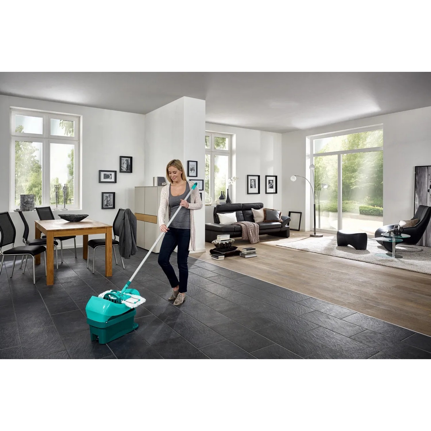 Frau nutzt Leifheit Wischtuchpresse Profi mit Rollen zum Reinigen von Fliesenboden im Wohnzimmer.