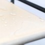 Beiger Vlies-Stoff des Relaxdays Schuhschranks mit Wassertropfen. Oberfläche ist leicht zu reinigen.