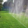 Gardena Schlauch-Regner 15m bewässert Rasenfläche im Garten mit feinem Sprühregen.