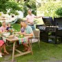 Familie grillt mit dem Jamestown Kombigrill Drake im Garten. Holzkohlegrill mit Gasgrill und Smoker.