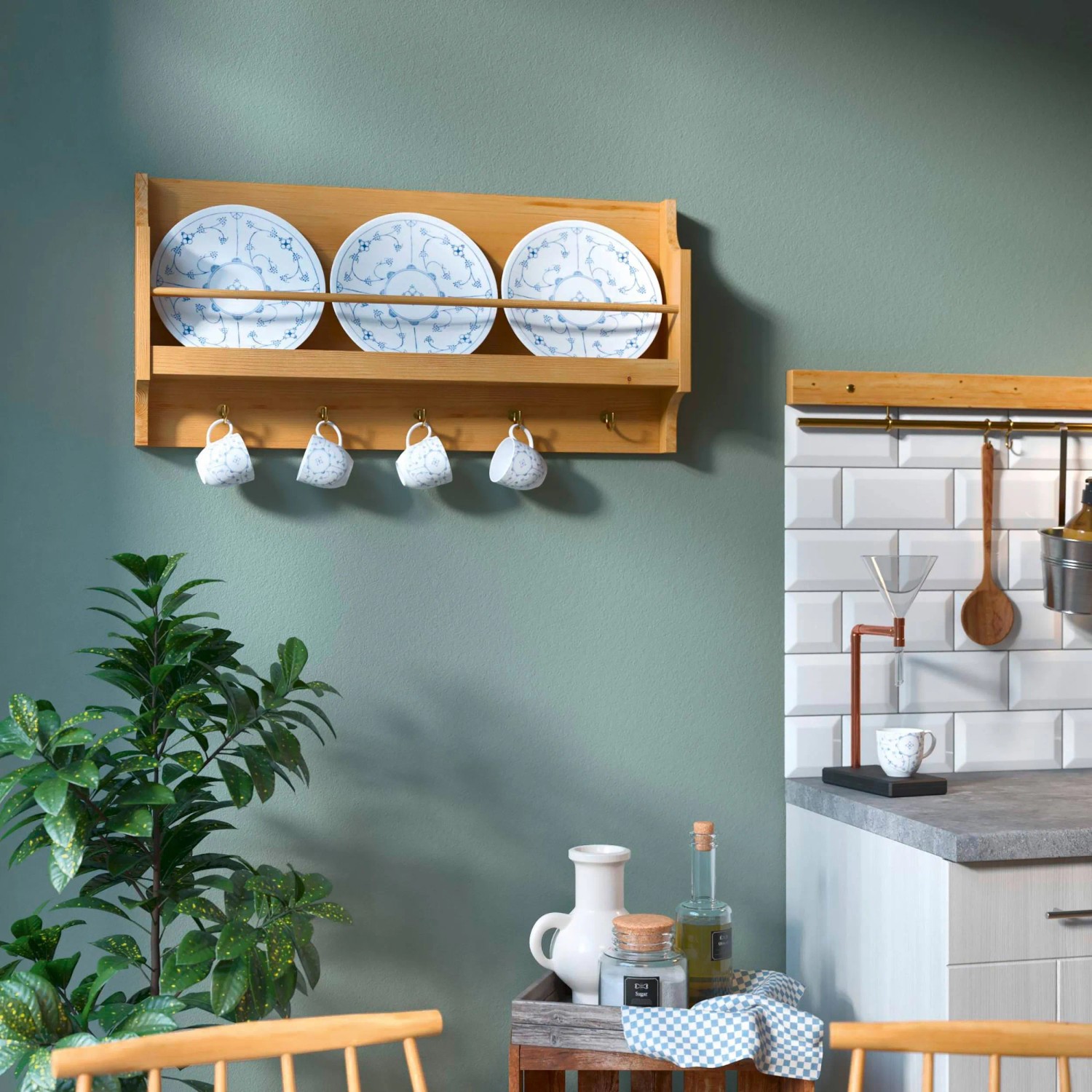 Wand in Agavengrün mit Holzregal, Tellern und Tassen. CREATE! by OBI Wandfarbe.
