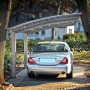 Ximax Carport Portoforte-80 im Edelstahl-Look mit Auto. Moderner Metallcarport mit gebogenem Dach.