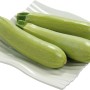 Helle Zucchini auf einem Teller, Grow by OBI, ideal für Gemüsebeete und den Frischverzehr.