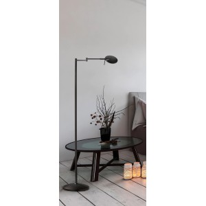 Schwarze, matte Trio LED Stehleuchte Kazan neben Tisch mit Dekoration.