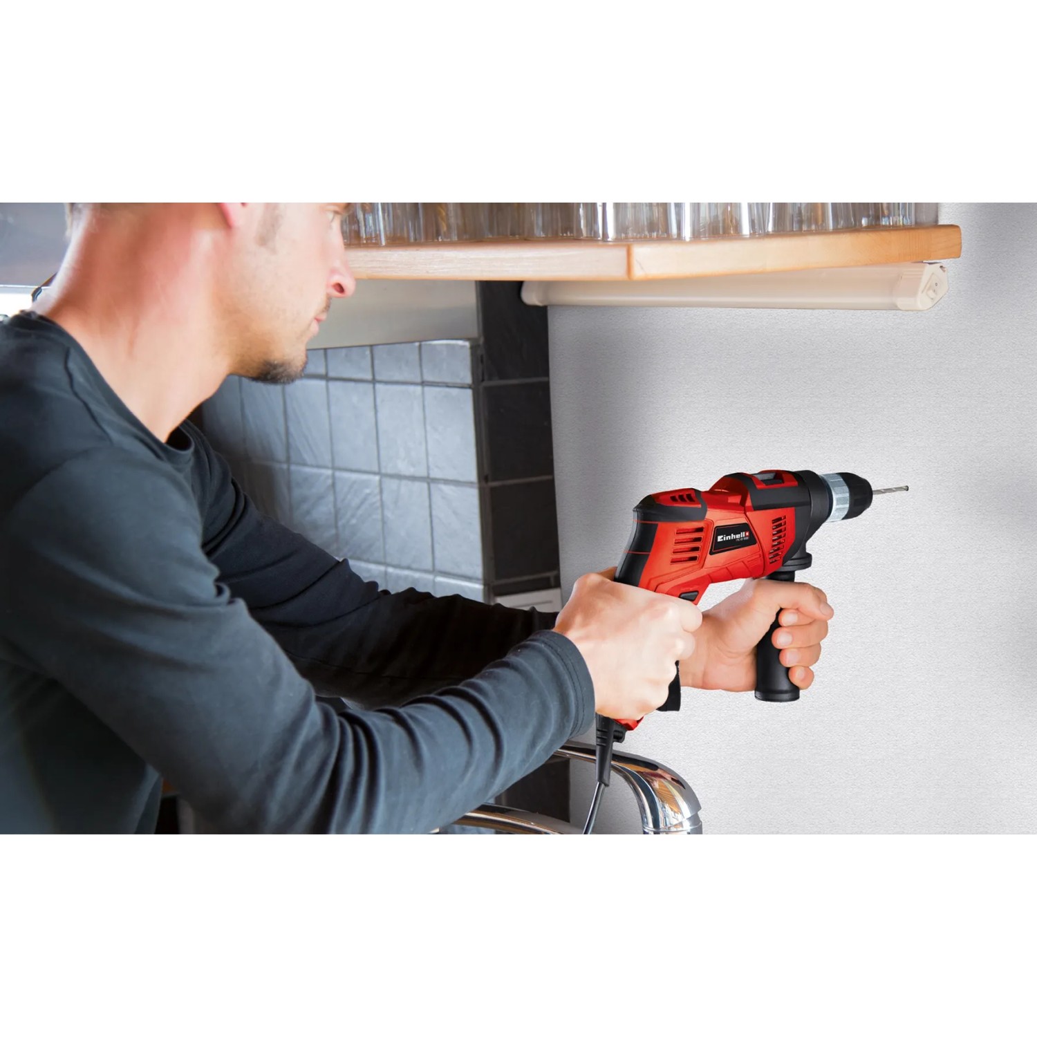 Einhell Schlagbohrmaschine TC-ID 550 E in Nutzung, rot/schwarz, beim Bohren in eine Wand.