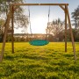 AXI Nestschaukel Summer Braun mit grünem Nest an Holzgestell im Garten.
