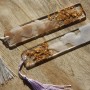 Zwei CreativEpoxy Epoxidharz Lesezeichen mit Quasten und Goldflocken auf Holz.