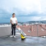 Frau reinigt Terrasse mit Kärcher PCL 4 und Bürstenwalzen für Steinflächen.