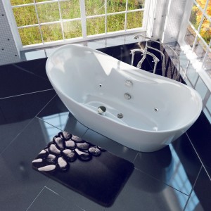 Sanilo Badteppich Hot Stones (70x110 cm) neben Badewanne auf dunklen Fliesen.