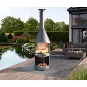 Buschbeck Gartengrillkamin Sydney, hellgrauer Grill mit Holz und Grillgut im Garten.