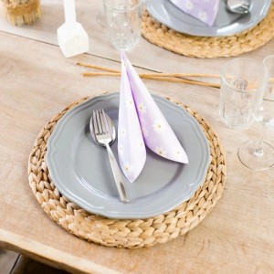 HMF Tischset rund, geflochten aus Wasserhyazinthe, auf Holztisch mit grauem Teller und lila Serviette. Stilvolles Platzset.