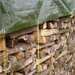Grüne Gewebe-Abdeckplane 210 g/m² schützt Holzstapel vor Witterung. Mit Ösen und Seilen befestigt.