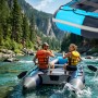 Zwei Personen paddeln in einem blauen Relaxdays Schlauchboot auf einem Fluss. Robustes PVC-Aluminium-Boot für Wassersport.