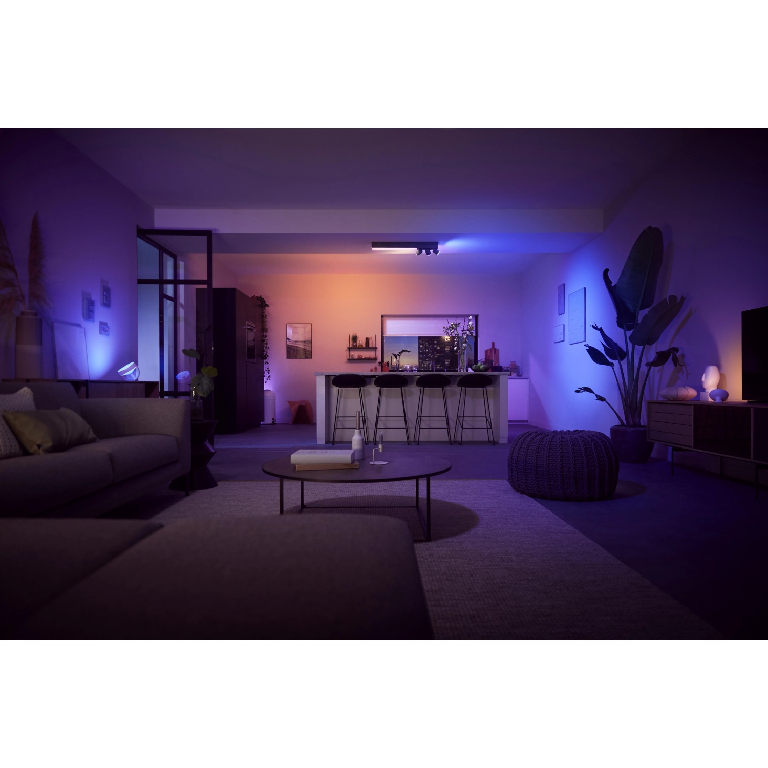 Schwarze Philips Hue Centris LED-Deckenleuchte mit 3 Spots in Wohnraum-Szene mit farbiger Beleuchtung.