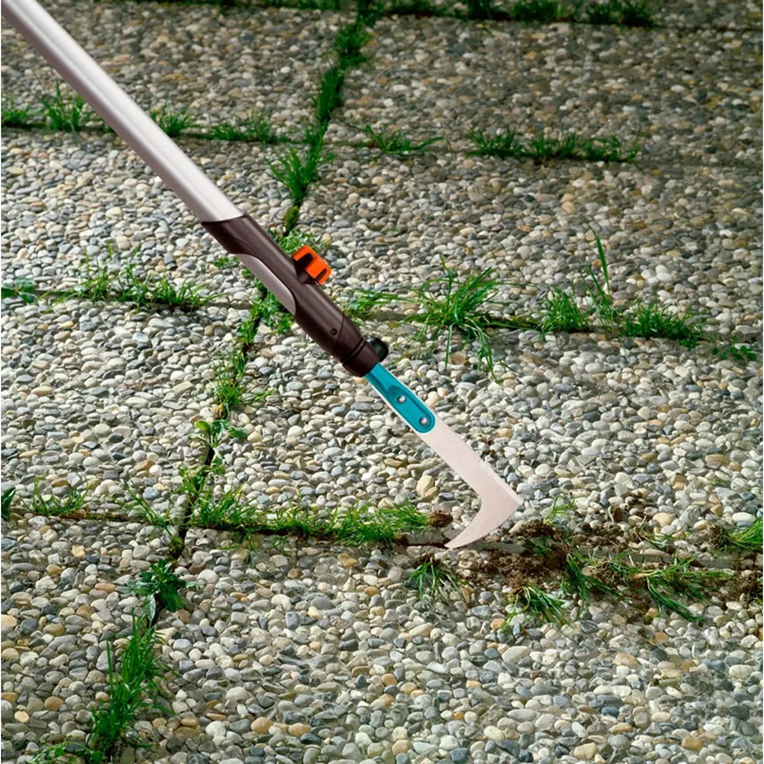 Gardena Fugenkratzer mit Holzstiel im Einsatz zum Entfernen von Unkraut zwischen Pflastersteinen.