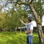 Mann sägt Ast mit Gardena combisystem Gartensäge 300 P am Baum im Garten.