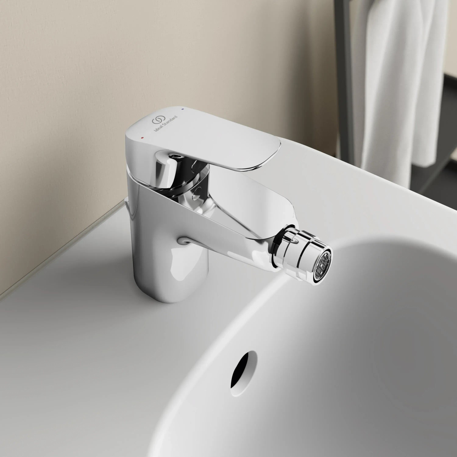Ideal Standard Ceraflex Bidetarmatur in Chrom auf einem weißen Bidet.