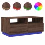 Moderner Couchtisch in Braun Eichen-Optik mit blauer RGB-LED-Beleuchtung, Schubladen und offenen Fächern.