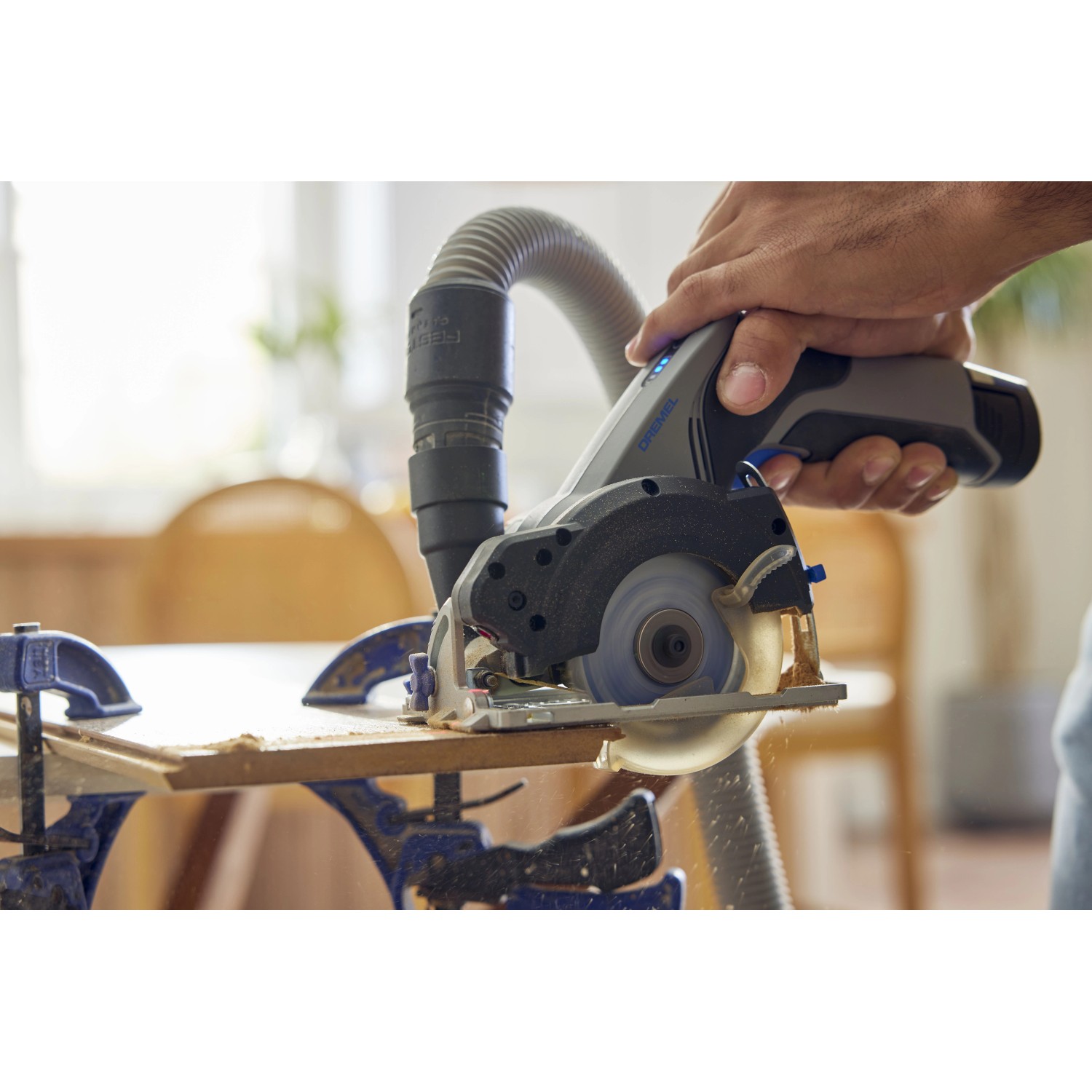 Dremel Kreissäge CS12V-S1C im Einsatz mit Staubabsaugung und Werkstück.
