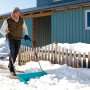 Mann schiebt Schnee mit Gardena Schneewanne 70 cm. Schneeschieber mit Stahlkante für große Flächen.