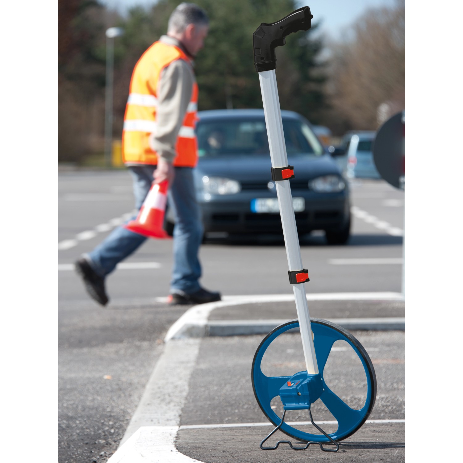 Bosch Professional Messrad GWM 32 auf einer Straße, eine Person im Hintergrund.