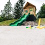 Axi Spielhaus Max mit Rutsche und Sandkasten im Garten, braun/grün.