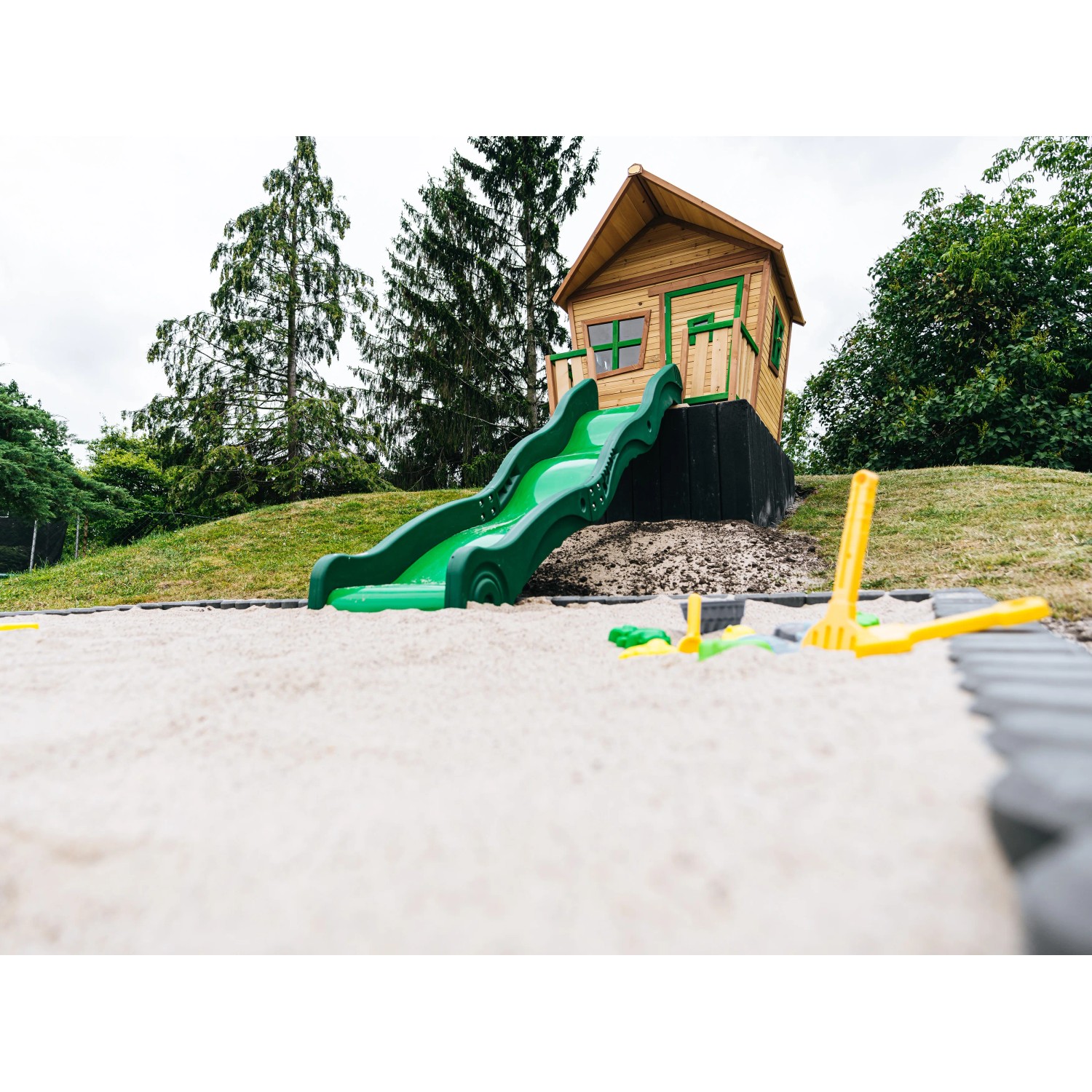 Axi Spielhaus Max mit Rutsche und Sandkasten im Garten, braun/grün.