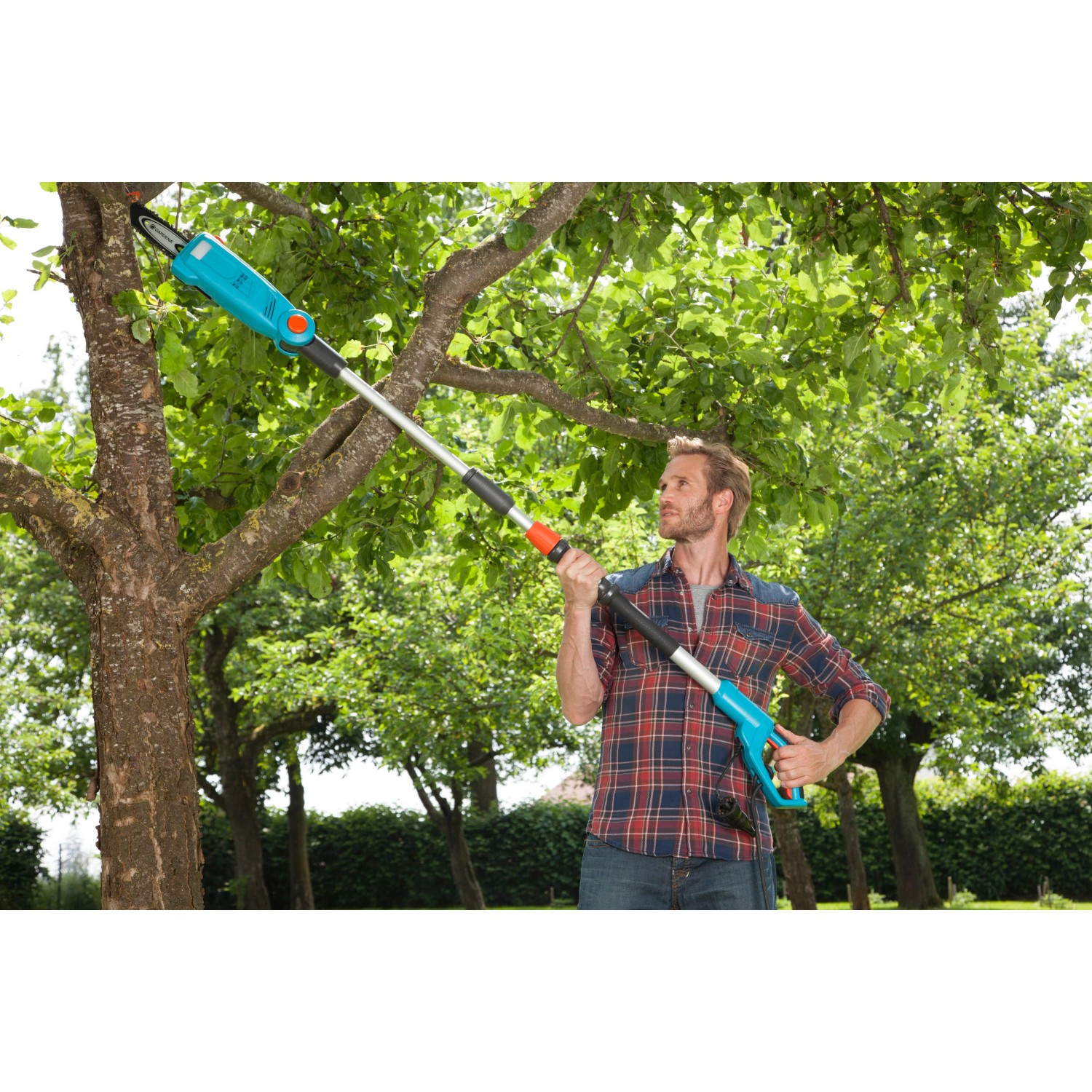 Mann schneidet Ast mit Gardena Elektro-Teleskopsäge TCS 720/20 Hochentaster im Garten.