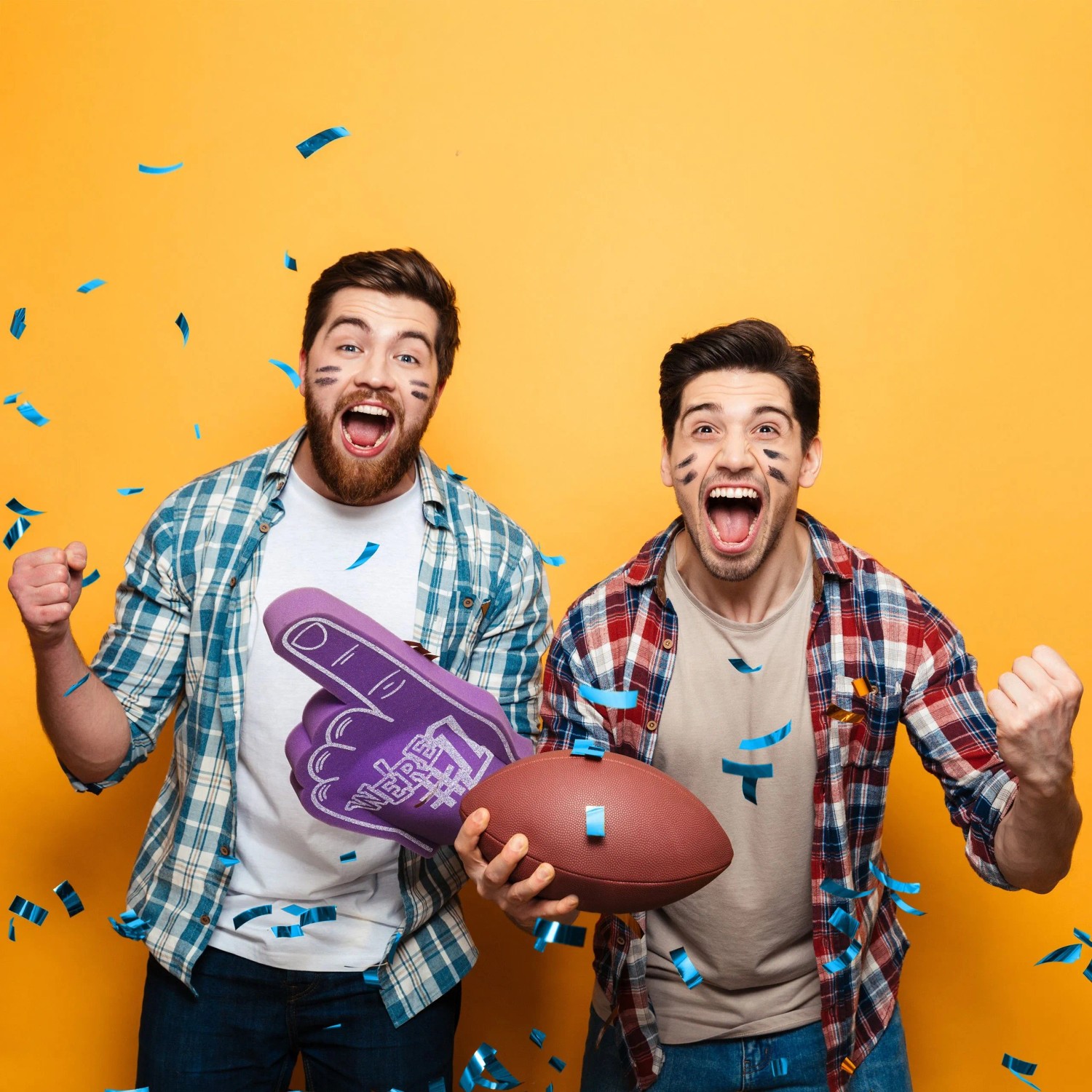 Zwei Männer jubeln im blauen Konfettiregen, einer mit Football. Perfekte Party-Stimmung für Konfettikanone.
