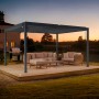 Graue Cazeboo Piana Bioklimatische Pergola 4x3m mit Lounge-Möbeln auf Holzterrasse.