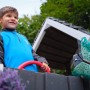 Kind am Steuer des Fatmoose Spielturm BoldBaron mit Rutsche, Apfelgrün.