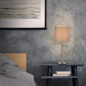 Brilo Tischleuchte Fabric in Taupe mit Stoffschirm auf Nachttisch.