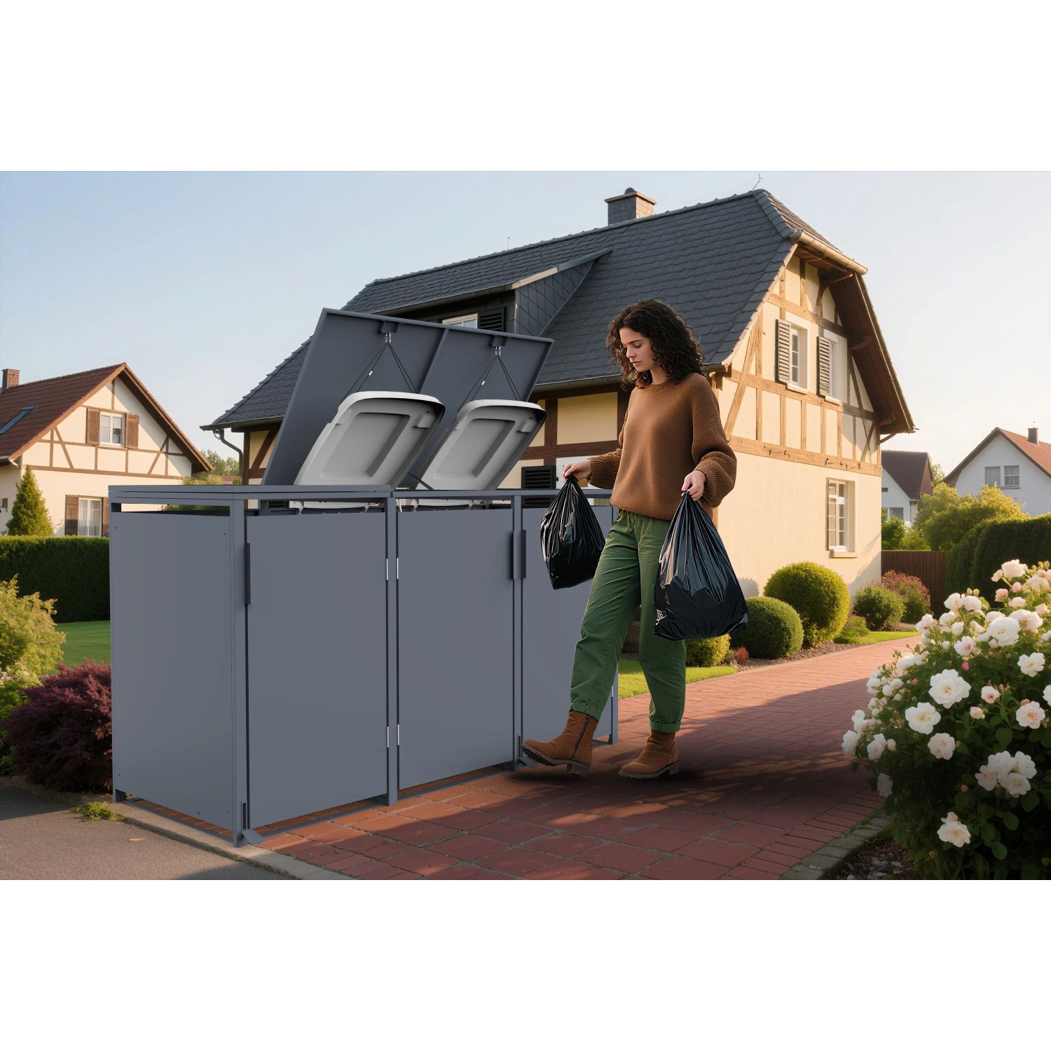 Anthrazitfarbene FM-SOLAR Mülltonnenbox für 3 Tonnen im Garten. Frau entsorgt Abfall, Deckel mit Gasdruckfeder offen.