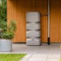 Garantia Gartentank Cubus 700 l in Betongrau vor Holzwand. Robuster Regenspeicher für Garten und Terrasse.