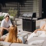 Enders Gasgrill Monroe Pro 4 SIKR Turbo Shadow mit Personen im Garten.