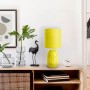 Gelbe Näve Tischleuchte Erida aus Keramik auf einem Sideboard. Design-Tischlampe für Wohnraum.
