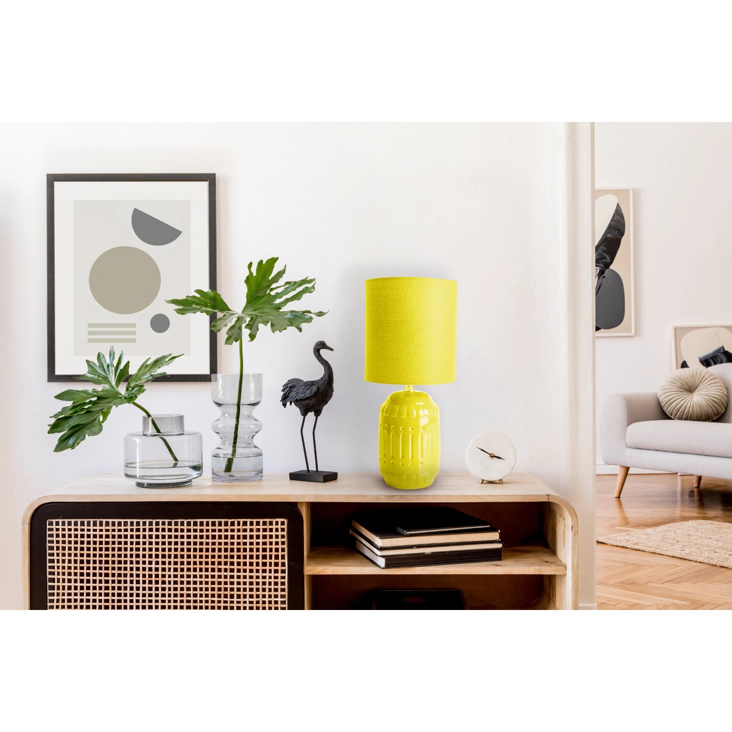 Gelbe Näve Tischleuchte Erida aus Keramik auf einem Sideboard. Design-Tischlampe für Wohnraum.
